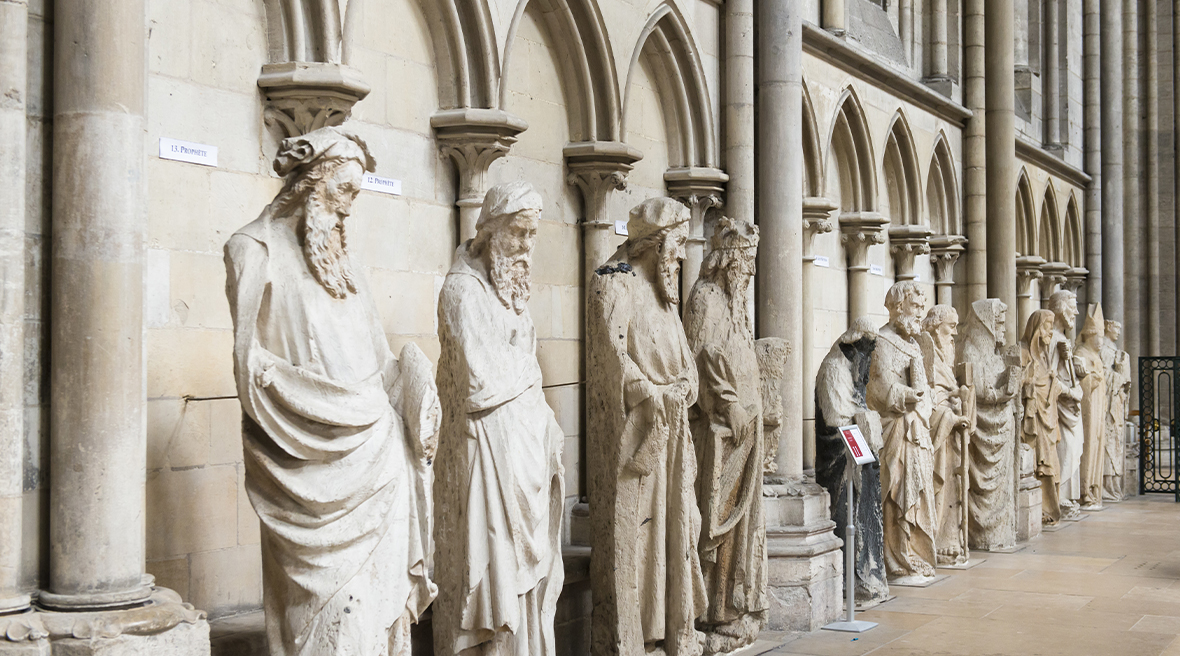 White stone statues in a Gothic style inside archways of a church